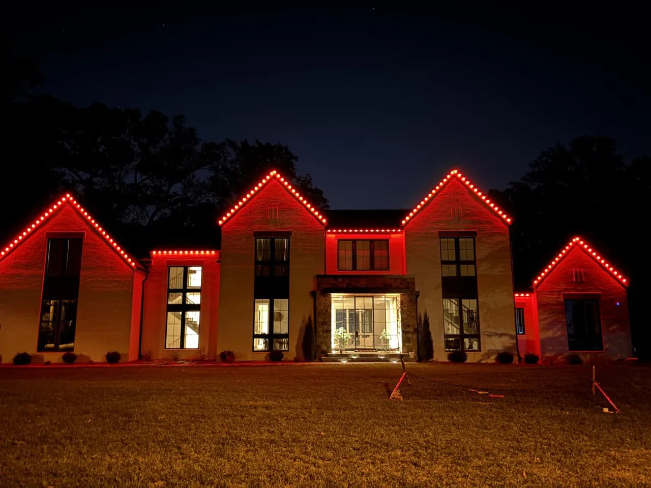 Permanent LED lighting in Vienna, VA by Light DMV — same roofline lit red for game day and the holidays at night