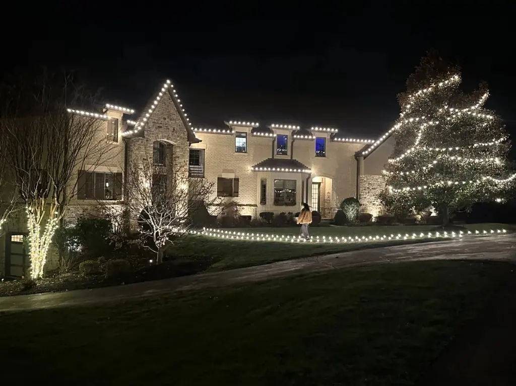 DMV home at night with warm white roofline lights, tree wraps, and a fully lit pathway installed by Light DMV