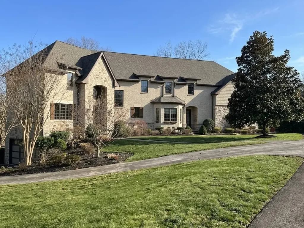 Same stone-and-stucco DMV home during the day before professional holiday light installation by Light DMV