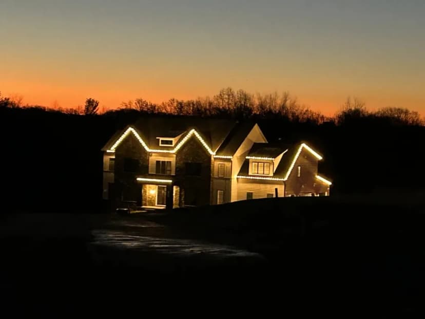 Christmas light installation in the DMV by Light DMV — warm white roofline at dusk on a custom home