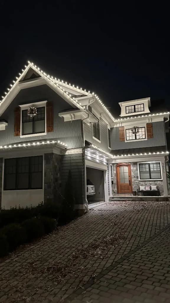 Christmas light installation in the DMV by Light DMV — warm white roofline and wreath accents at night