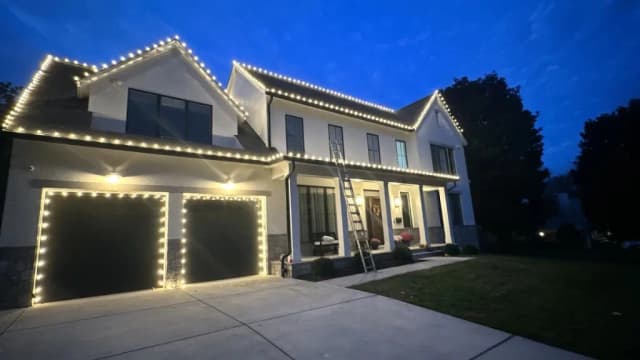 Christmas light installation in the DMV by Light DMV — warm white lights and tree wrap near the driveway