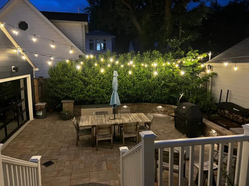 Bistro string lights over a backyard deck at night in the DMV by Light DMV