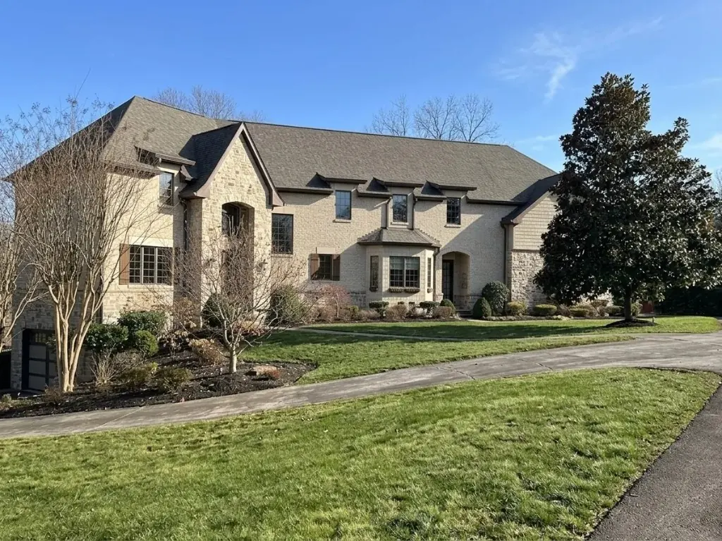 Same stone-and-stucco DMV home by day, before holiday lighting — LightDMV