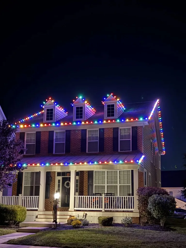 Christmas light installation in the DMV — colorful C9 roofline on a brick home