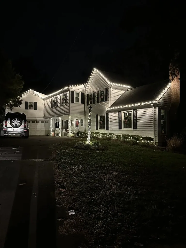 Christmas light installation in the DMV — warm white roofline on a suburban home at night