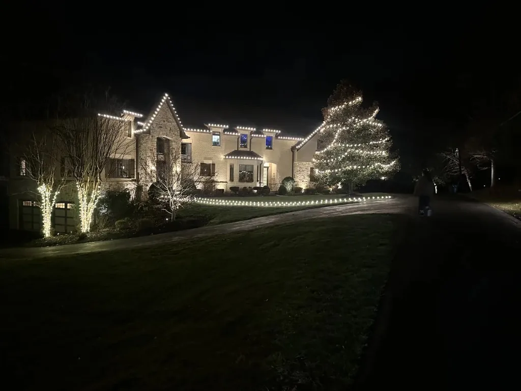 Christmas light installation in the DMV — broad warm white roofline on a large home